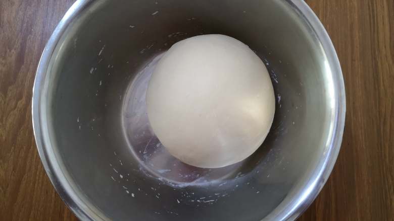 葡萄干小面包,面团变得很光滑，能拉出结实的薄膜时，从面包桶中取出，整成圆形，放入盆中，盖上保鲜膜，室温发酵。
