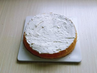 双层奶油蛋糕,将8寸的蛋糕片成两片，取一片涂抹上打好的奶油。