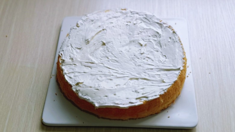 双层奶油蛋糕,将8寸的蛋糕片成两片，取一片涂抹上打好的奶油。