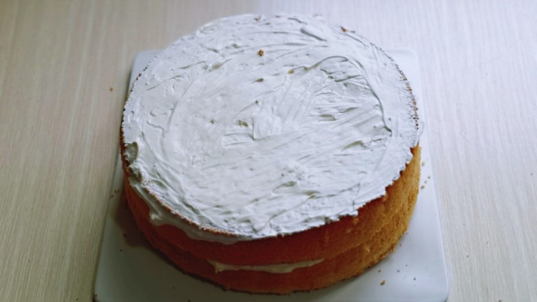 双层奶油蛋糕,把另一片盖上，再涂抹上奶油，把6寸的放在上面，抹上奶油。