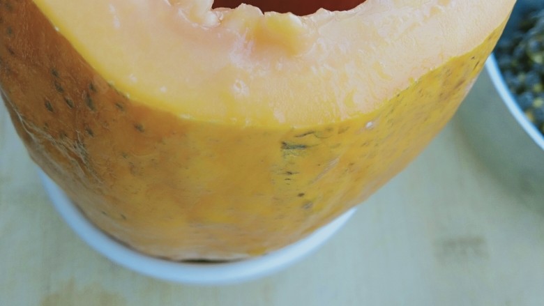 木瓜牛奶冻,把木瓜放到一个和木瓜大小的碗里，直立固定。
