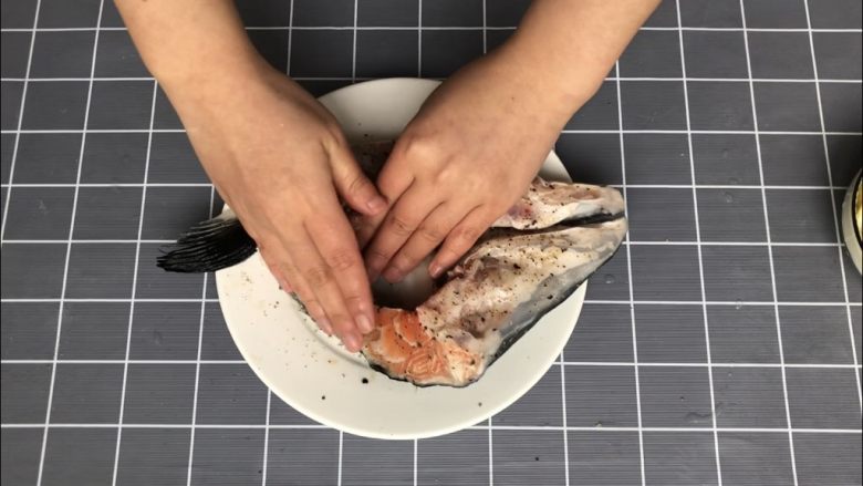 盐烤三文鱼头,用手充分按摩鱼头1-2分钟