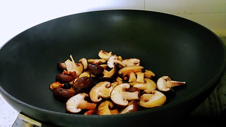 油菜香菇,加入香菇翻炒。由于放的油比较少，炒的过程中锅中太干，可加点清水进去。
