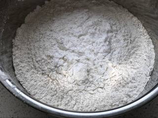 青团,糯米粉、澄面、白砂糖混合在一个容器中，倒入加热过的艾草泥，用筷子搅拌抱成团，稍微晾凉。
