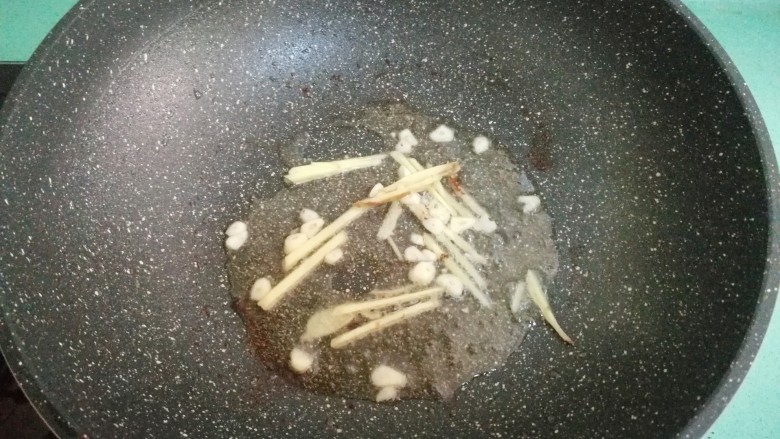 酒酿烧带鱼,锅里的油不用换掉，直接放入姜丝和蒜瓣，爆出香味