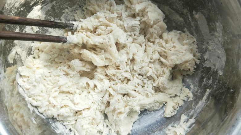 苹果豆沙包,然后把酵母水倒进面粉里，油也倒进去。（加食用油，猪油都可以）然后加牛奶，一边加一边搅拌，直到没有干面粉，像图中棉絮状，就可以了