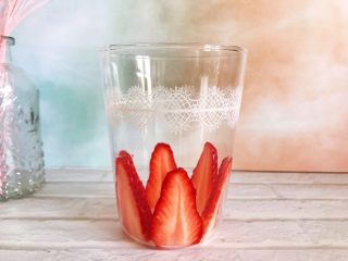 粉嫩少女心～草莓酸奶昔,将草莓片贴在玻璃杯内，如图所示