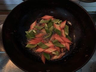 菠萝咕咾肉,锅中倒入适量的油，油热倒入胡萝卜片和青椒翻炒