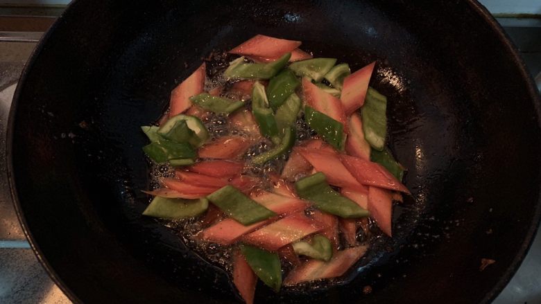 菠萝咕咾肉,锅中倒入适量的油，油热倒入胡萝卜片和青椒翻炒