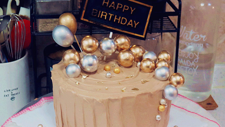 低调的奢华~【巧克力奶油生日蛋糕】,放上生日牌和金银小装饰球，再放几个金银糖球