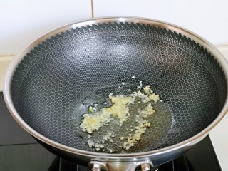 豌豆炒萝卜干,起油锅，加入蒜末炒出香味。