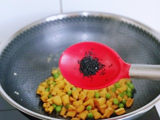 豌豆炒萝卜干,再加入熟黑芝麻翻炒均匀，关火出锅。