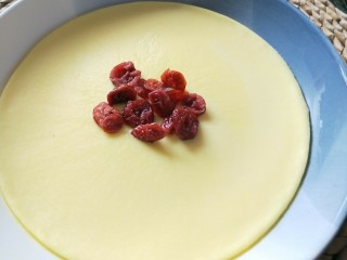 蔓越莓牛奶蒸蛋,取一些蔓越莓装饰在表面。