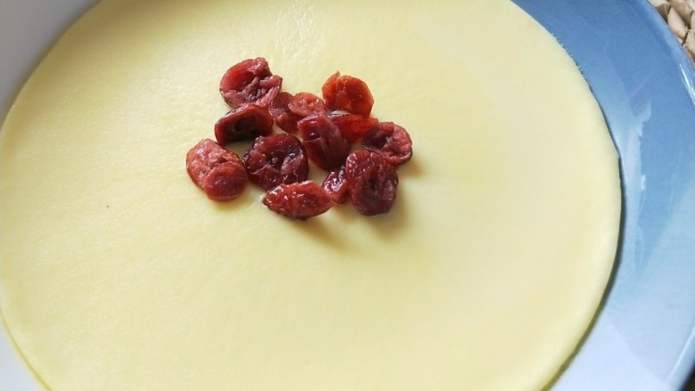 蔓越莓牛奶蒸蛋,取一些蔓越莓装饰在表面。