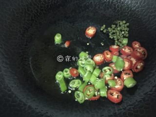 青花椒辣卤小龙虾,起油锅，把青红尖椒和青花椒倒入煸炒至出香味。