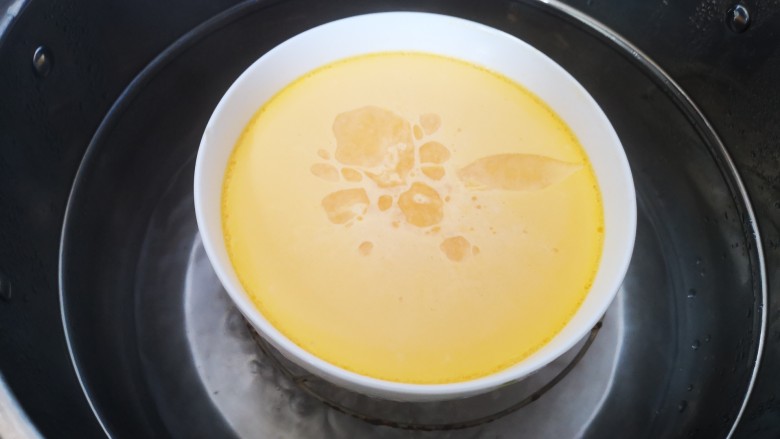 干贝蒸蛋,蒸至蛋液表面基本凝固后打开盖子和盘子