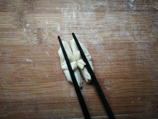 盛开的莲花,再竖着在两边使劲先压后向中间挤压，筷子转一下抽出来