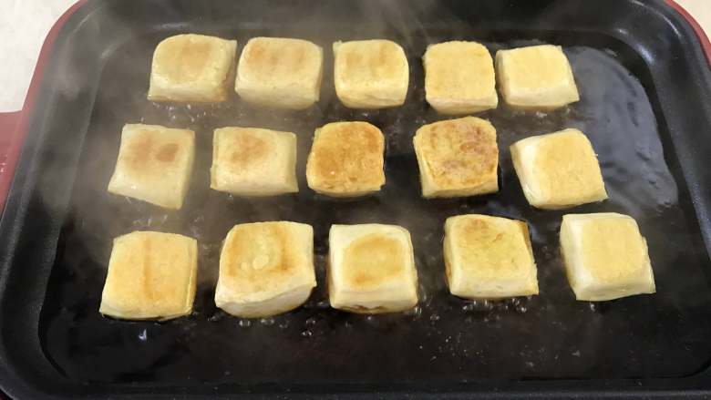 照烧豆腐,煎好后，把调好的酱汁倒入烤盘中。