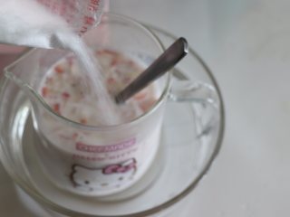 自制健康美味的草莓牛奶果冻,倒入适量的白砂糖，搅匀融化。