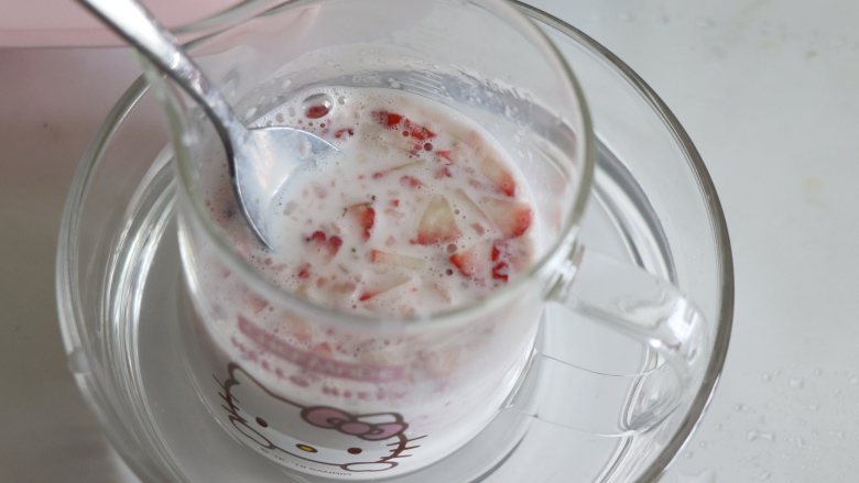 自制健康美味的草莓牛奶果冻,把切好的草莓放到牛奶中热到水分稍微烫手，大约40-50度。