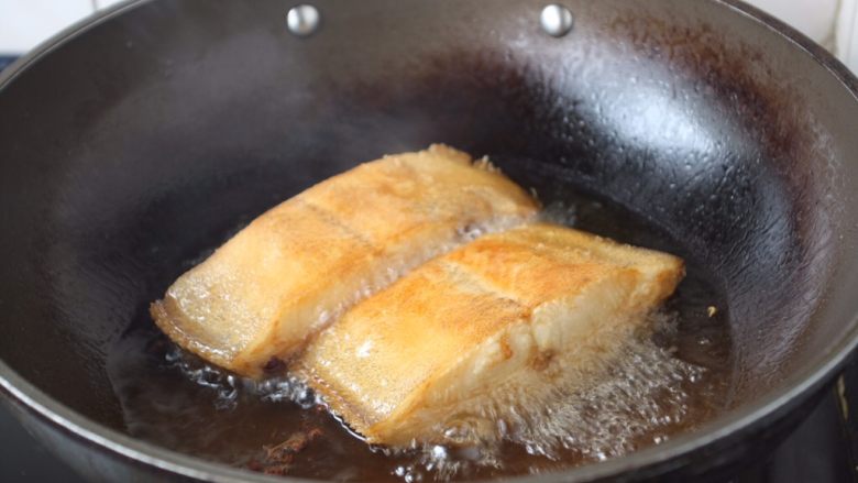 红烧鲽鱼段,当鱼的一面煎至金黄色时翻过来再煎另一面，两面都煎至金黄色就OK了，然后依次将其它的鲽鱼块煎至金黄色。
温馨提示：
（1）当把鱼刚刚放到锅里后千万不要急于翻动，如果翻动了，肯定会粘锅的，因为油很热，鱼和铲子都是凉的，热油一下子就会“抱住”铲子和鱼，肯定会粘锅。 
（2）那么我们什么时候才能翻动鱼呢，a，中火煎制至少2分钟后才能翻动。b，还有就是被煎鱼的那面有明显的金黄色才可以翻动。c，再有就是当离火晃动锅时，鱼可随意在锅里滑动也可以翻动。建议初学者用第2种方法判断什么时候翻动鱼。