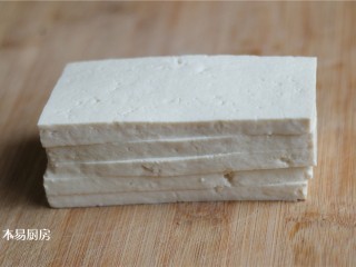 香椿拌豆腐,老豆腐冲洗干净，放在砧板上，先切成约0.5厘米左右的薄片。