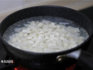 香椿拌豆腐,把豆腐放入水中焯30秒至1分钟。焯水这一步必不可少，可以将豆腥味去掉，这样口感更好一些。