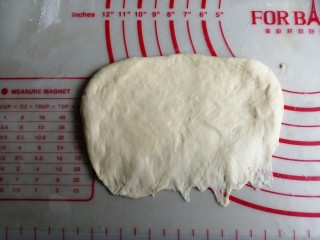 炼乳花环面包,擀成椭圆形，将光滑面朝下，压薄底边