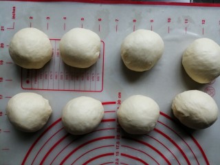 炼乳花环面包,将面团取出，轻压排气，分成8份，滚圆后盖上保鲜膜，松驰20分钟