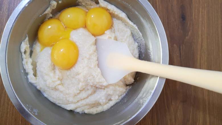 古早蛋糕,将蛋黄分两次与面糊混合，用刮刀搅拌均匀。