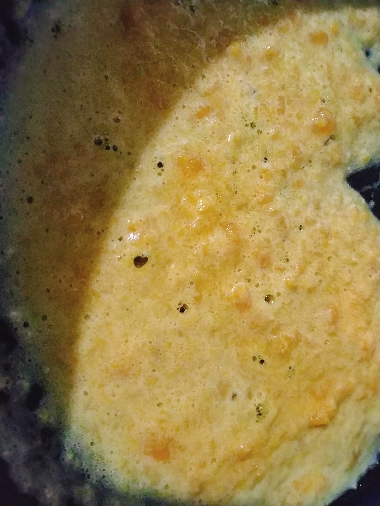 蟹黄豆腐,炒到咸鸭蛋黄冒沫沫；如果加火腿丁和胡萝卜丁豌豆在这步加入，翻炒均匀；