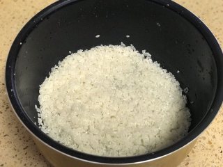 腊肠焖饭,大米淘洗干净倒出淘米水备用。