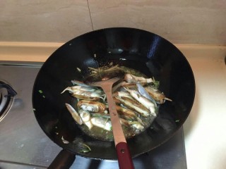 海鲜蛏子面,倒油，中火。放入小葱，再倒入蛏子翻炒2分钟