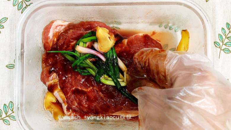 叉烧肉,用手抓拌，让肉均匀地沾到酱汁，把姜片和葱结一起放入保鲜盒中，搓一搓，以使入味