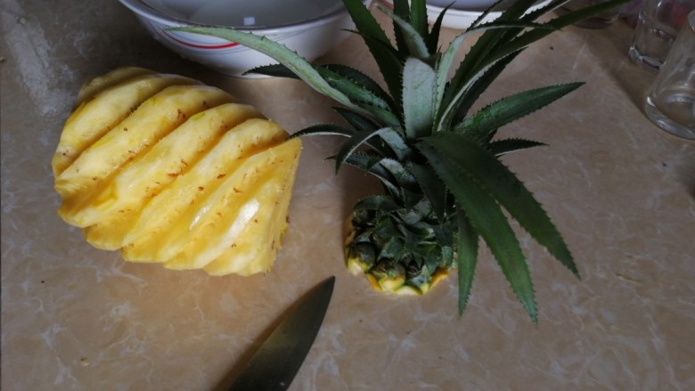 冰爽菠萝块,从头部切去菠萝叶子。