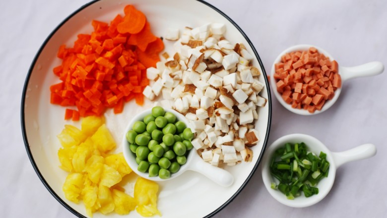色彩缤纷的菠萝炒饭,香菇，胡萝卜，火腿，香葱切丁，豌豆剥粒。