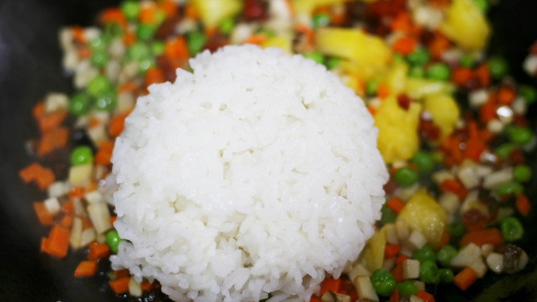 色彩缤纷的菠萝炒饭,转最小火加入米饭翻炒均匀。