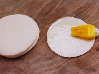 三丝春卷～饺子皮版,取一张饺子皮，用刷子蘸少许花生油，在饺子皮上涂抹均匀。