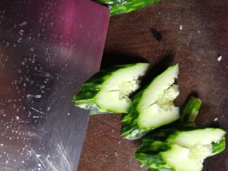 凉拌拍黄瓜,斜刀将黄瓜片成约1厘米厚的小块，装入盘中。