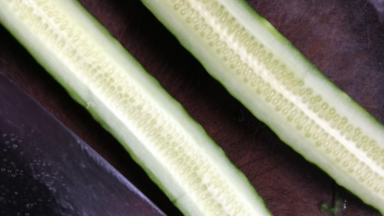 凉拌拍黄瓜,对半切开，拿刀的侧面轻轻拍黄瓜至微扁。