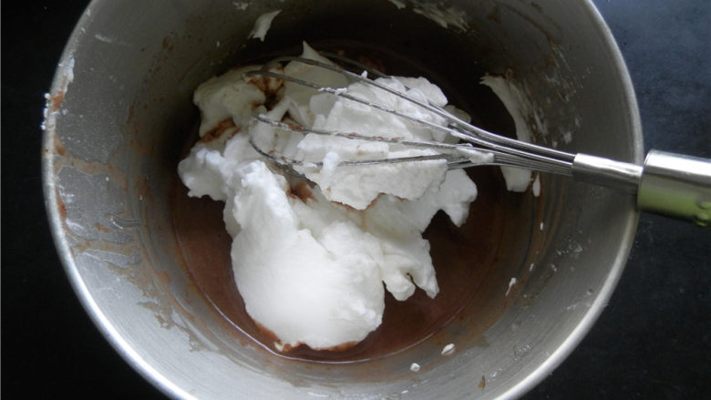 巧克力杯子蛋糕,取1/3的蛋白霜至蛋黄糊中，翻拌均匀。