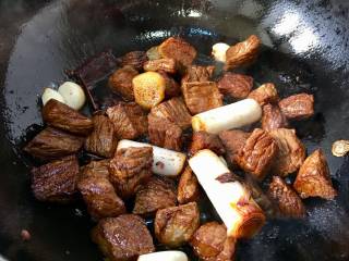 麻辣牛肉干丝,加入料酒翻炒片刻，再加入适量的生抽和老抽。