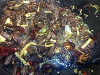 麻辣牛肉干丝,锅里放入多一点的菜籽油 ，放入葱姜蒜，干辣椒段，花椒爆香，加入牛肉丝干煸片刻