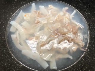 芦笋炒鱿鱼,锅里放入一大碗水烧开，把鱿鱼放入焯烫1分钟，焯好捞起来用冷水冲洗干净待用。