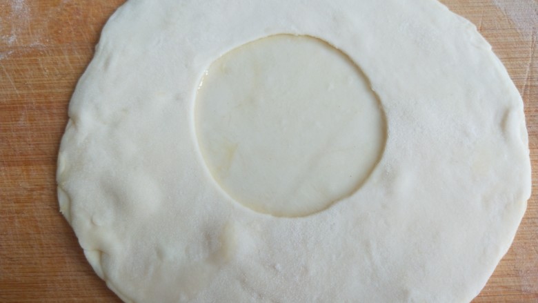 早餐鸡蛋灌饼,在把有口的面皮落在刷过油的面皮上，饼皮边轻轻压紧。