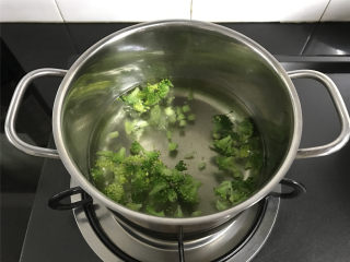 西兰花肉松饭团,锅中倒入适量水，煮开后加入少许盐和几滴油，放入掰小的西兰花焯下水。