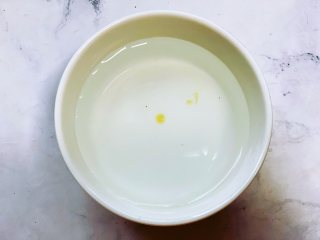 自制黑芝麻丸,准备一碗凉水，用筷子醮一点蜂蜜滴到水里，呈凝固的状态，不会马上散开就可以了。