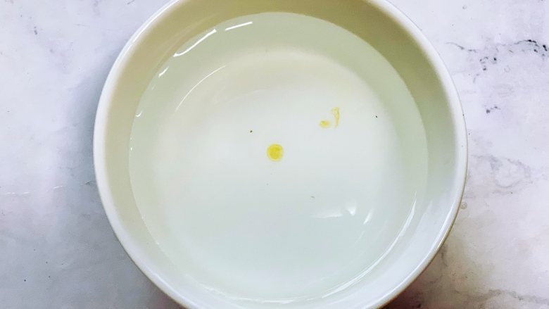 自制黑芝麻丸,准备一碗凉水，用筷子醮一点蜂蜜滴到水里，呈凝固的状态，不会马上散开就可以了。