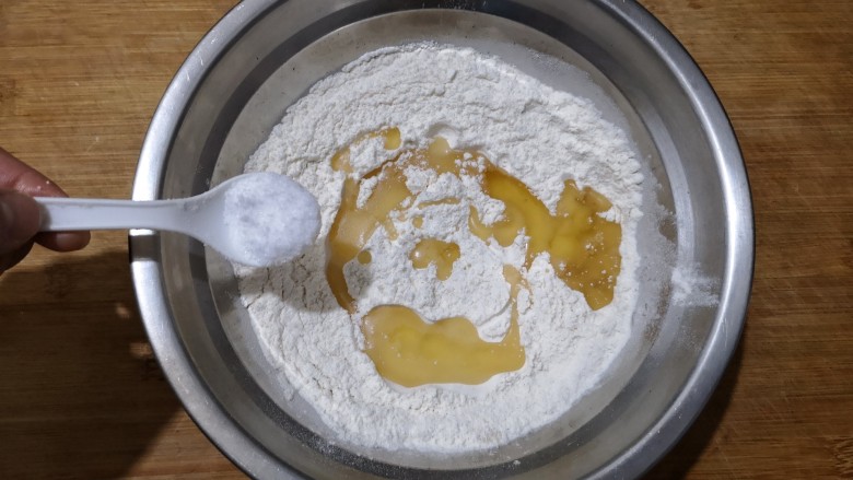 霜糖油条,在350克面粉中加入15克油，3克酵母粉和3克盐搅拌均匀。