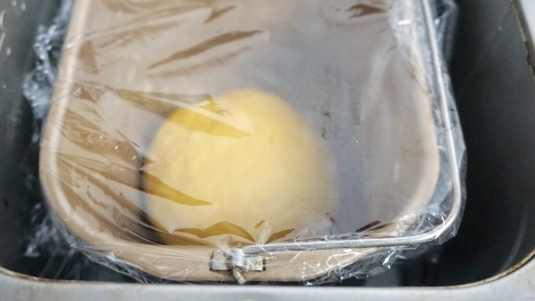 南瓜椰蓉面包条,加入软化黄油继续揉一个程序盖保鲜膜入面包机桶内发酵1小时
